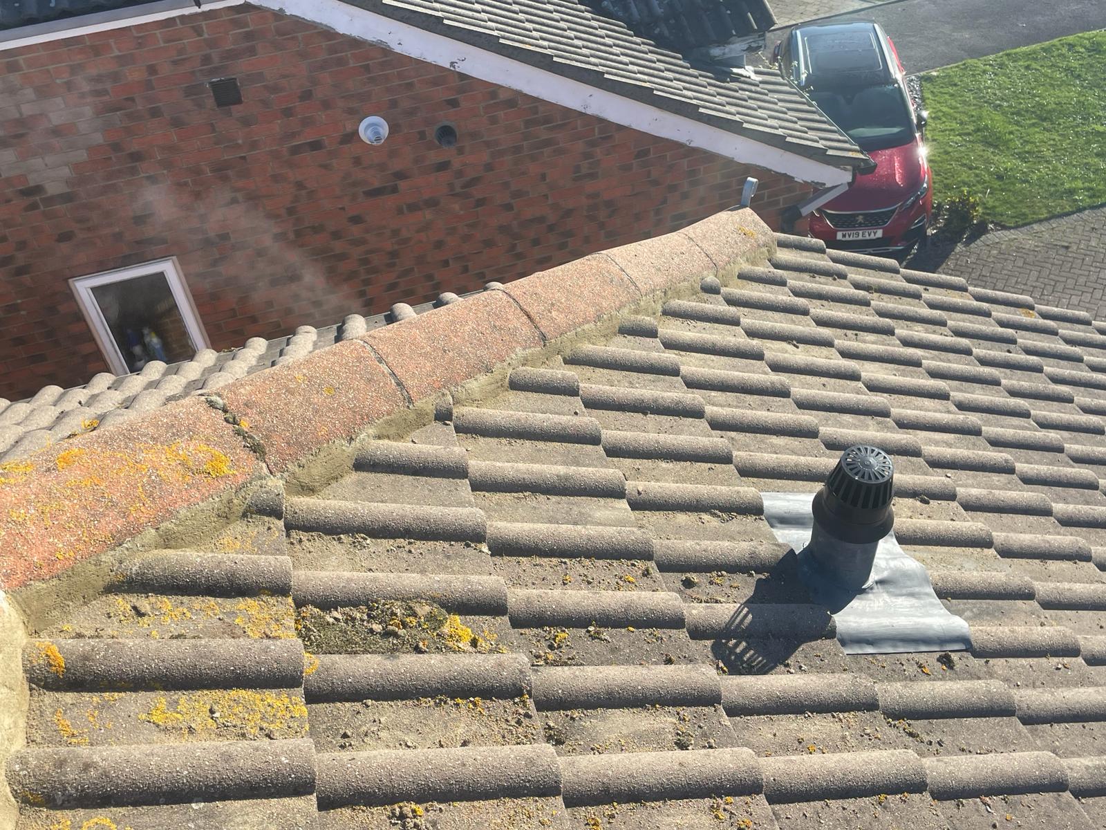 Bird's-eye view of South Coast Roofers' roofing work, with focus on the neatly arranged roof tiles and secure vent pipe installation.